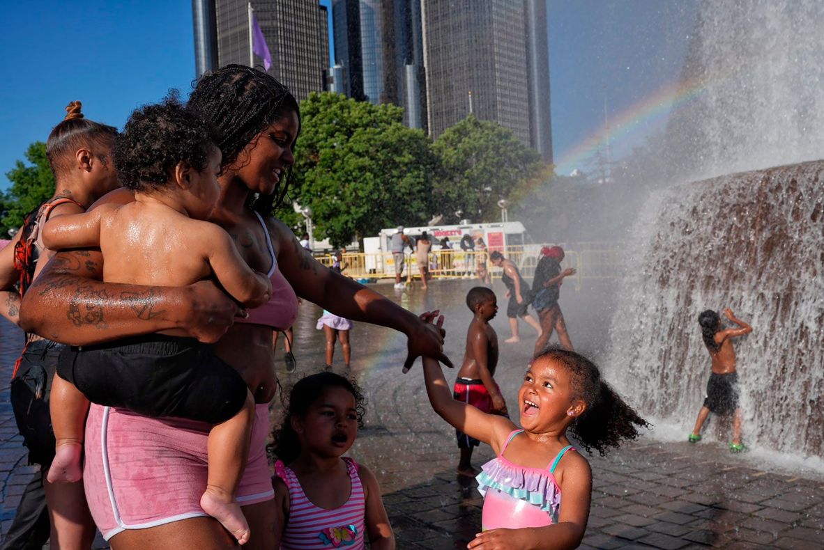 Kiara Daniels holds her son Kayson while twirling her daughter, Kehlani, at the Dodge Fountain in downtown Detroit’s Hart Plaza on Monday, June 23. They were waiting for the start of a fireworks show.