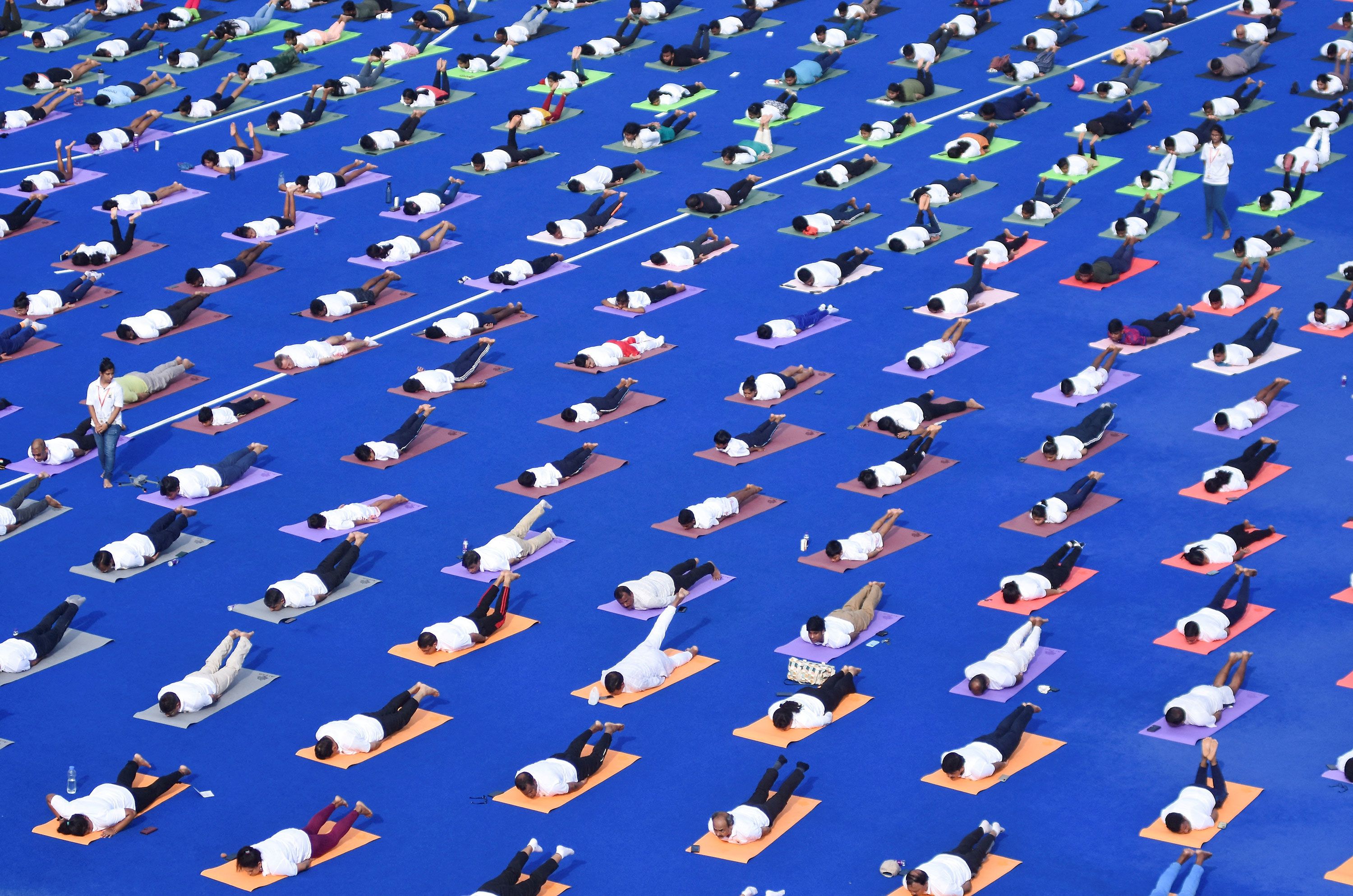 People perform yoga at Kalinga Stadium in Bhubaneswar, India, on Friday, June 21.