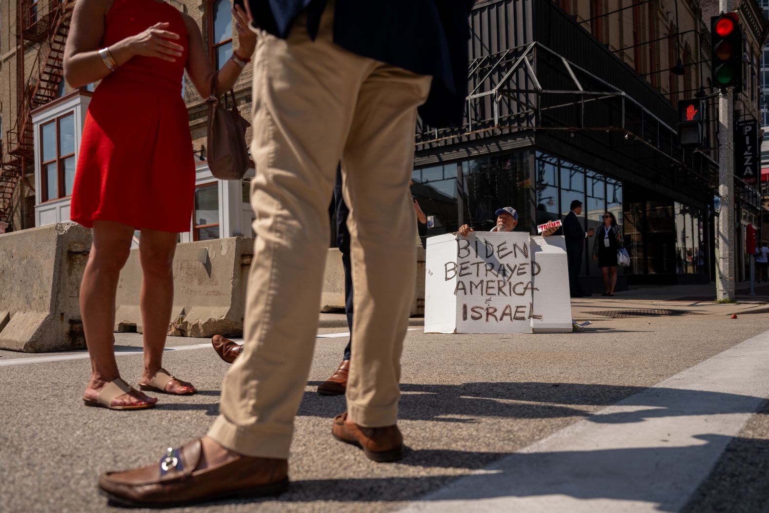 Bob Kunst, from Miami, holds a sign outside the Fiserv Forum on Sunday that read "Biden betrayed America and Israel."