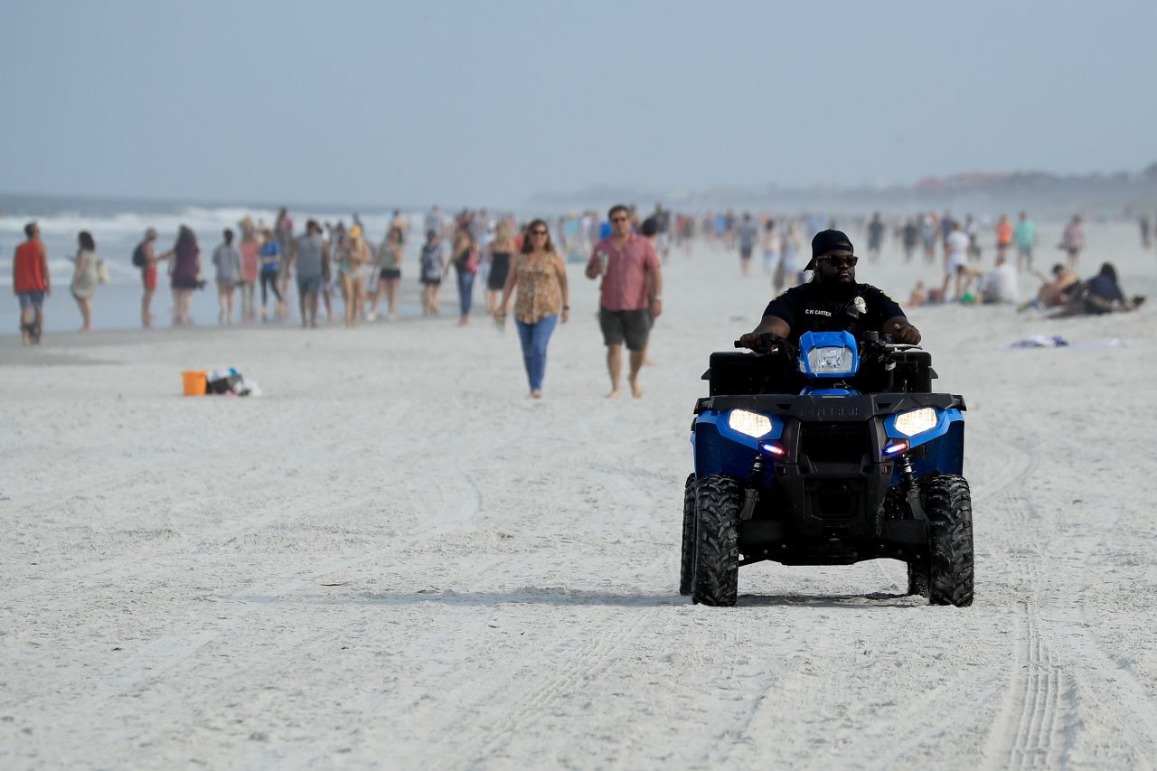 A policeman drives along the beach in Jacksonville Beach, Florida, on April 19.