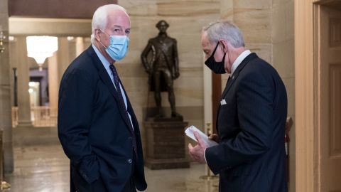 US Sen. John Cornyn, left, talks with Sen. Tom Carper in a corridor near the Senate chamber.