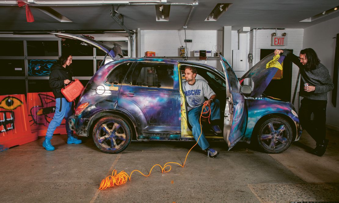 MSCHF team in their studio with the customized PT Cruiser used in their performance "Key4all."