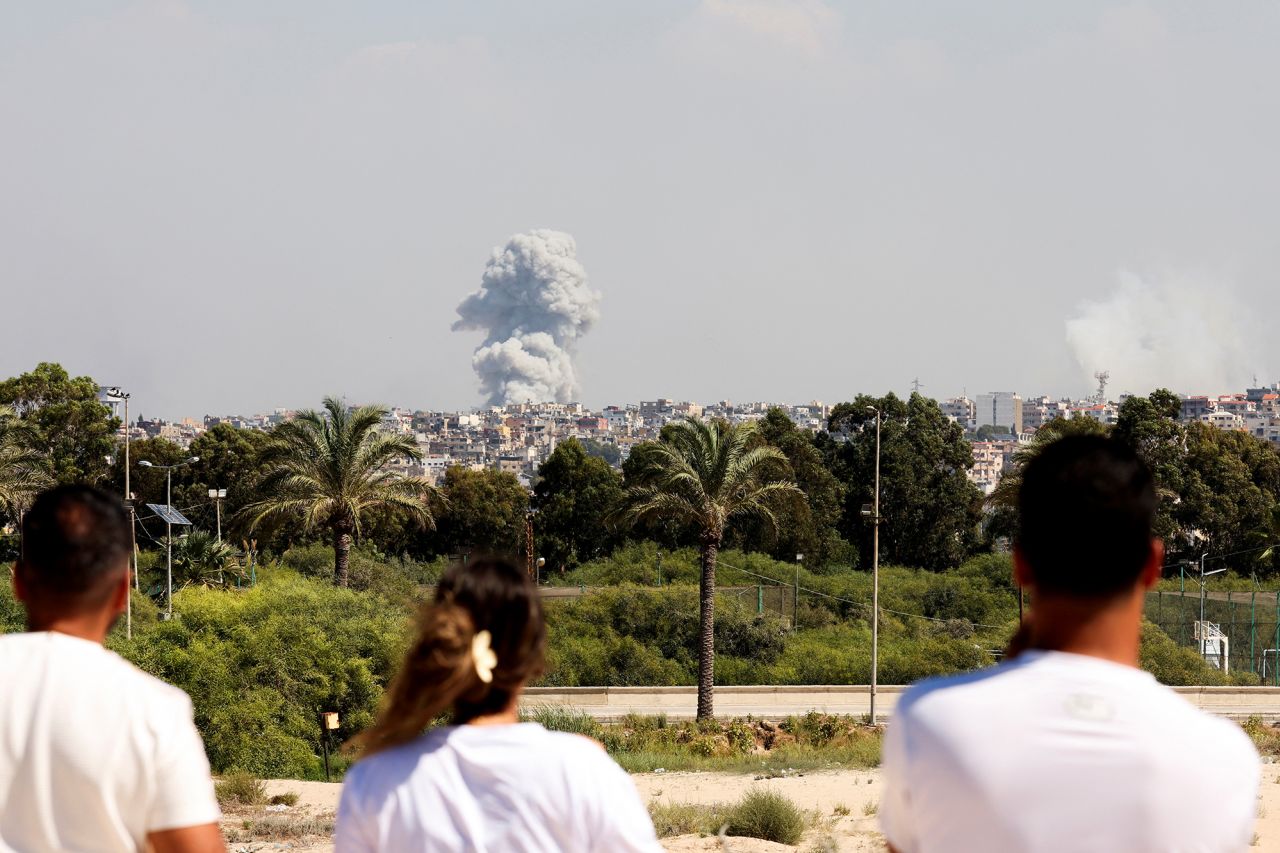 People watch as smoke billows over southern?Lebanon?following Israeli strikes on September 23.