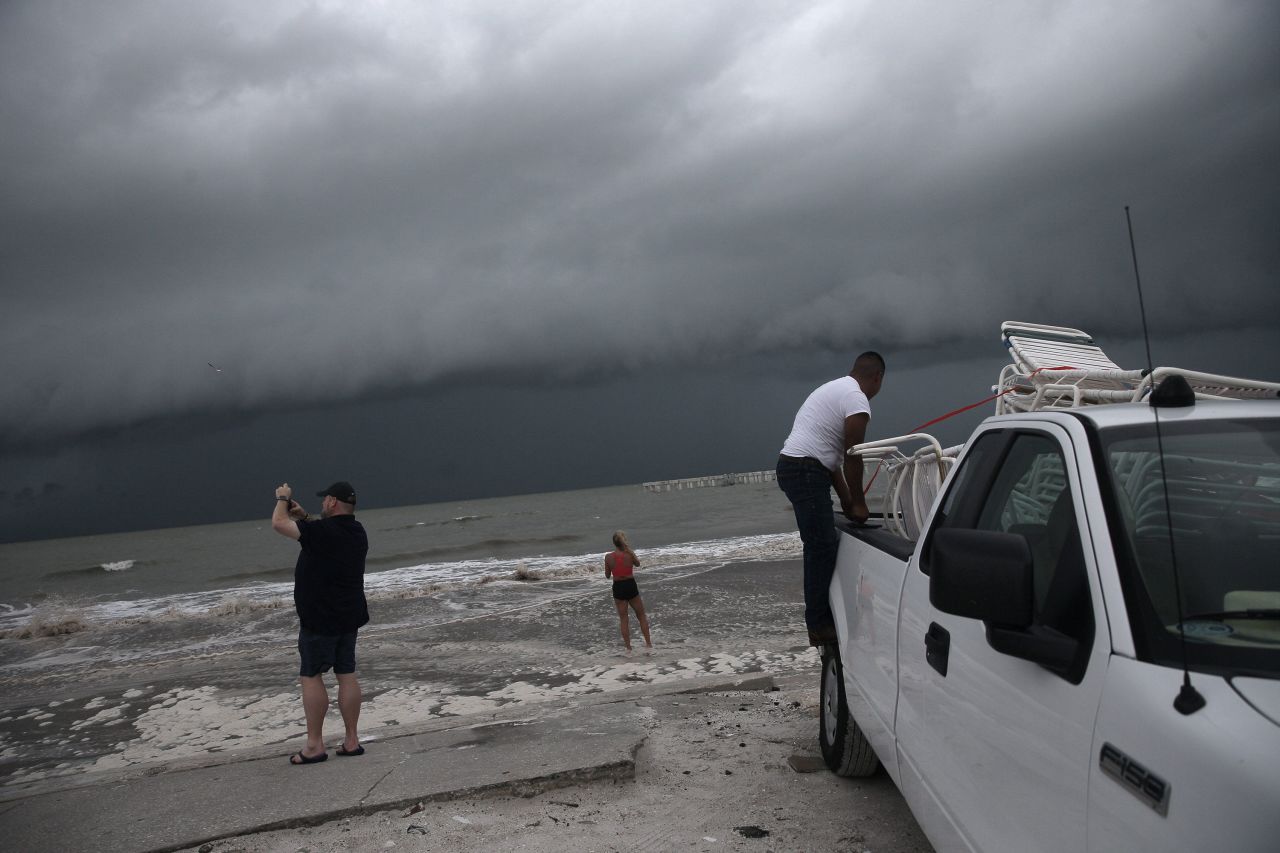 Beach chairs are loaded up to be taken away as beachgoers check out the surf on Fort Myers Beach.