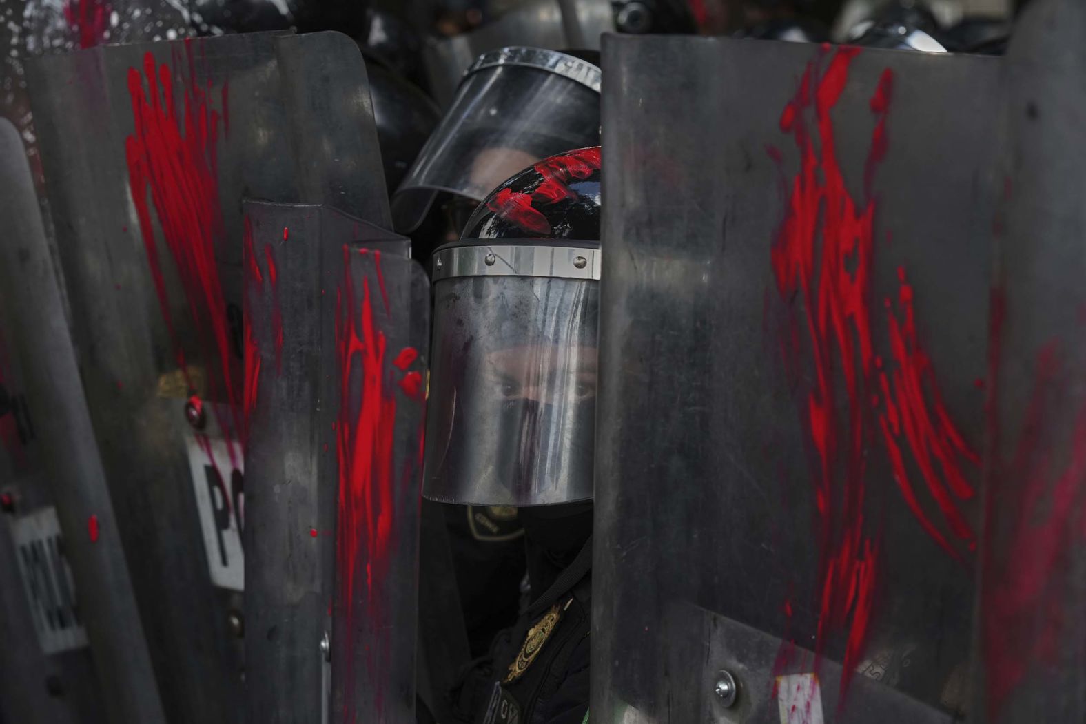 Police officers stand guard in Mexico City on Sunday, August 17, after demonstrators smeared paint on their shields at a protest against the war in Gaza.