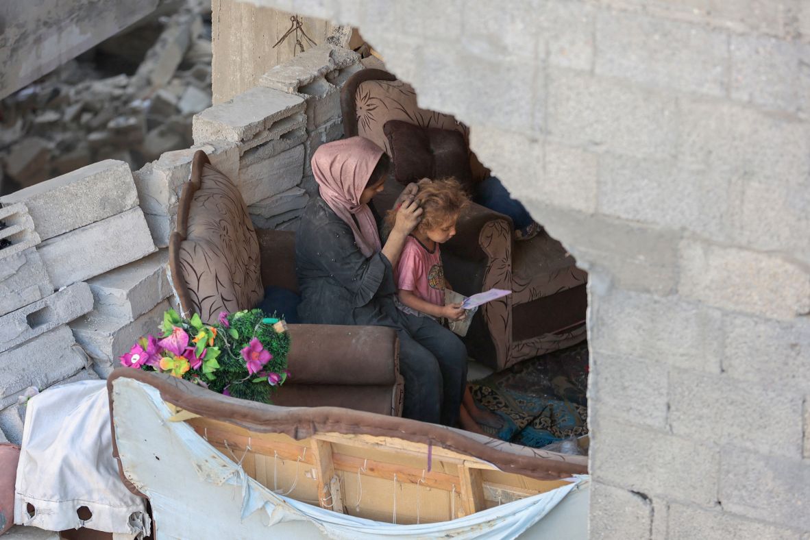 A Palestinian woman ties her daughter's hair after an Israeli strike on the Al-Shati refugee camp in west Gaza City on Wednesday, July 9.