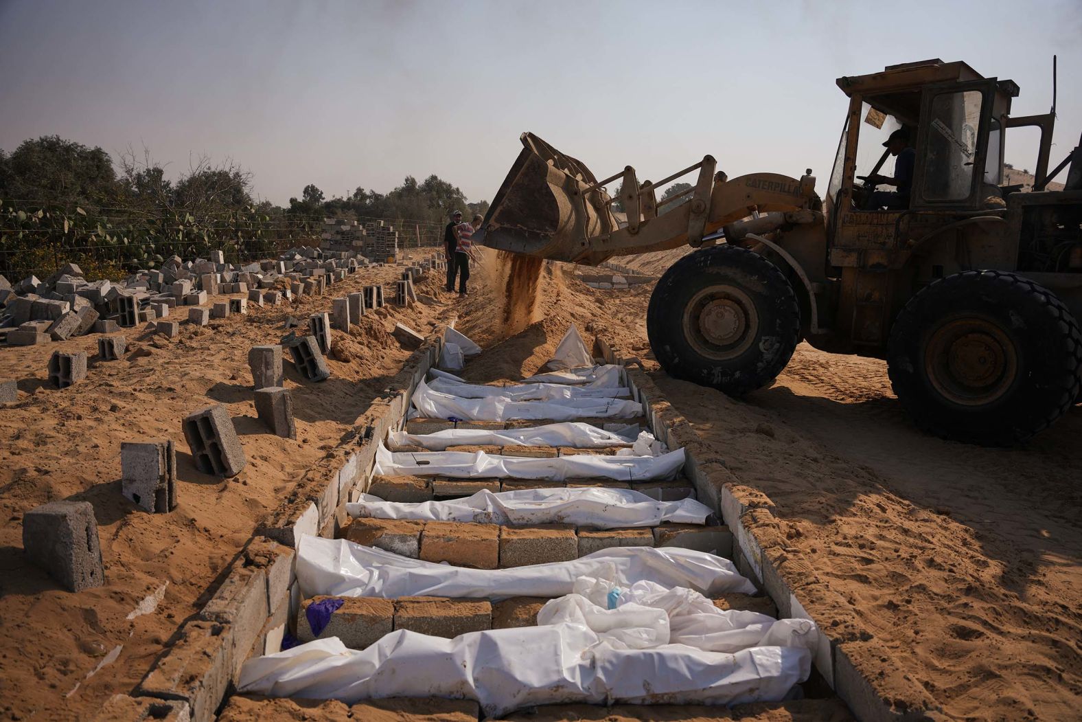 Bodies of unidentified Palestinians, returned from Israel as part of its <a href="index.php?page=&url=https%3A%2F%2Fwww.cnn.com%2Fworld%2Flive-news%2Fisrael-hamas-gaza-war-10-08-25">ceasefire deal with Hamas</a>, are buried in a mass grave in Deir al-Balah, Gaza, on Wednesday, November 5.