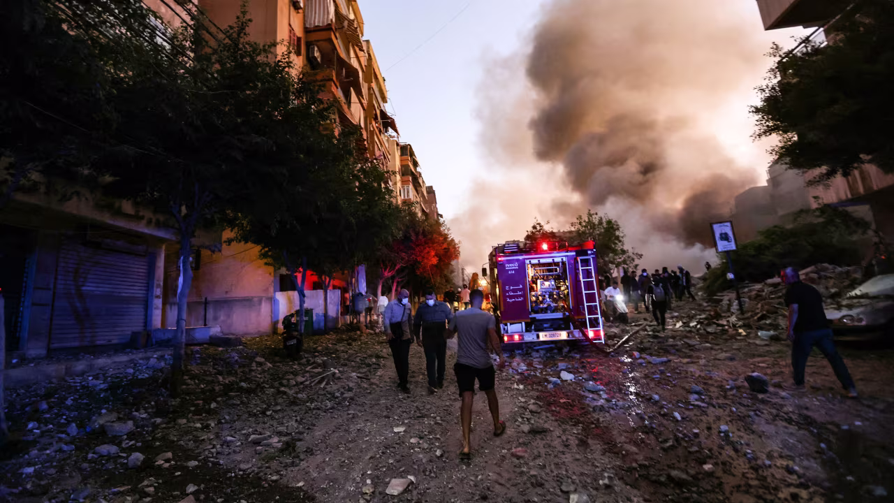 People rush to the scene of an Israeli airstrike in Beirut's southern suburbs on Friday.