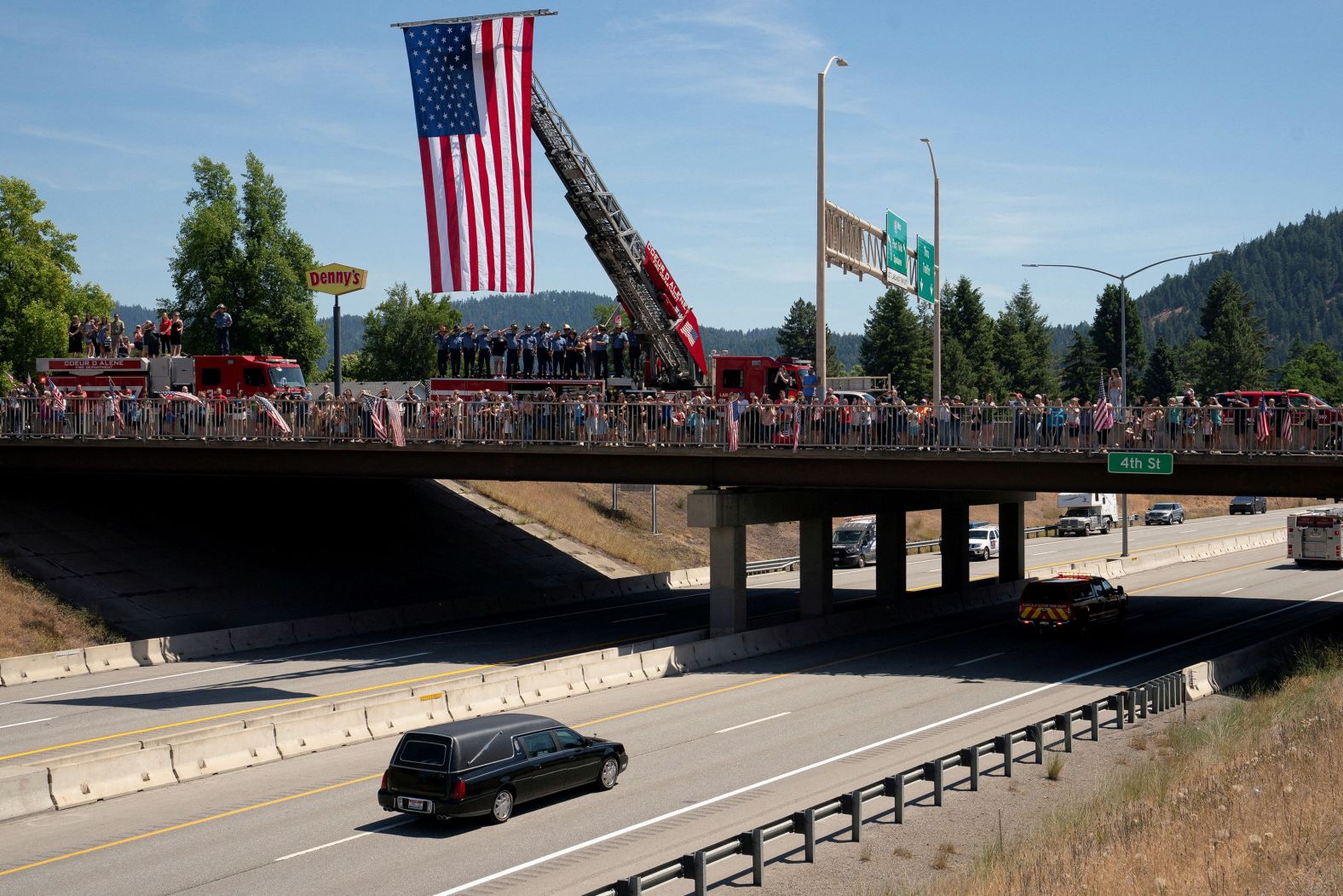 Firefighters and community members watch as a procession carrying the bodies of <a href="index.php?page=&url=https%3A%2F%2Fwww.cnn.com%2F2025%2F07%2F01%2Fus%2Fidaho-shooting-victims-firefighters">fallen firefighters John Morrison and Frank Harwood</a> passes under a bridge along Interstate 90 in Coeur d’Alene, Idaho, on Tuesday, July 1. The two men were fatally shot while <a href="index.php?page=&url=https%3A%2F%2Fwww.cnn.com%2F2025%2F06%2F29%2Fus%2Fcoeur-dalene-idaho-shooter">responding to a brush fire on Canfield Mountain</a> in what authorities described as a sniper attack. A third firefighter was also seriously injured in the shooting. The suspected gunman, <a href="index.php?page=&url=https%3A%2F%2Fwww.cnn.com%2F2025%2F06%2F30%2Fus%2Fidaho-fire-shooter-wess-roley">20-year-old Wess Roley</a>, was found dead at the scene, apparently from a self-inflicted gunshot wound. He is believed to have started the fire so he could target the responding firefighters, officials said.