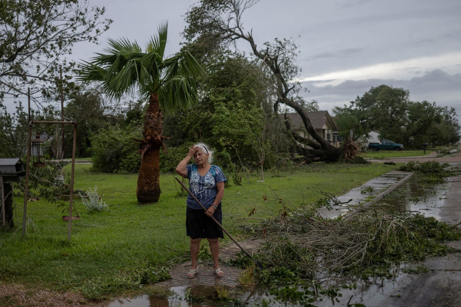 Maria Castillo grieves for her 85-year-old green ash tree after it was uprooted by <a href="index.php?page=&url=https%3A%2F%2Fwww.cnn.com%2F2024%2F07%2F02%2Fweather%2Fgallery%2Fhurricane-beryl%2Findex.html">Hurricane Beryl</a> in Freeport, Texas, on Monday, July 8. Beryl made landfall as a Category 1 hurricane, with sustained winds of 80 mph. It was the first storm of the Atlantic hurricane season to make landfall in the United States.