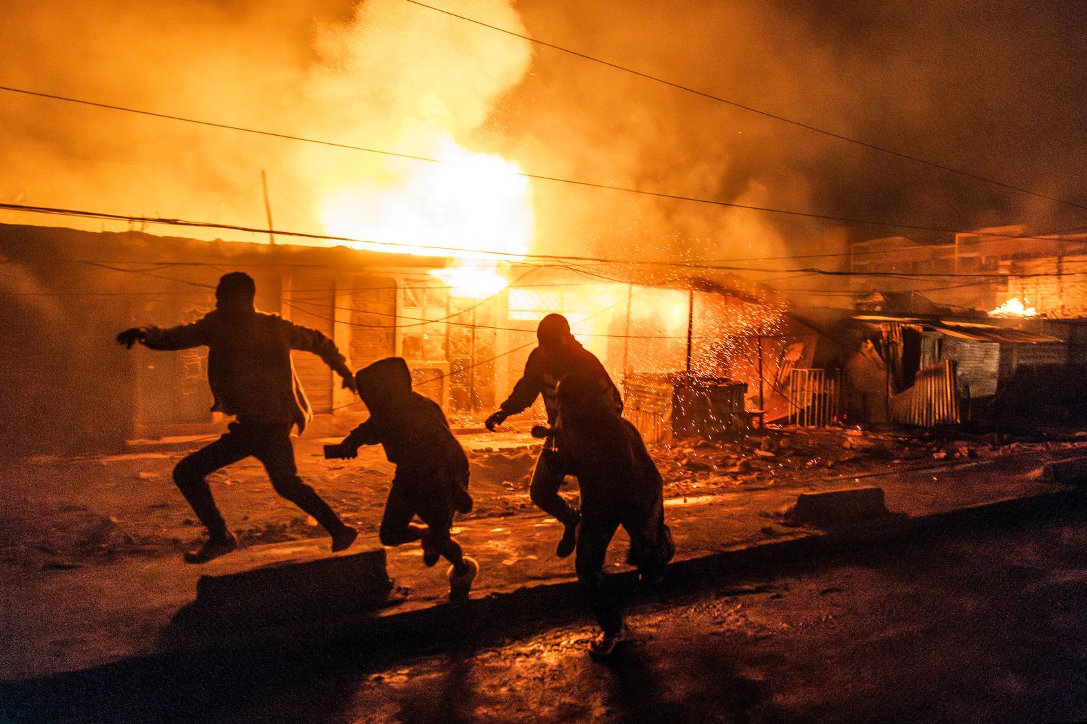People run for cover following an explosion in the Embakasi district of Nairobi, Kenya, on Friday, February 2. <a href="index.php?page=&url=https%3A%2F%2Fwww.cnn.com%2F2024%2F02%2F02%2Fafrica%2Fkenya-nairobi-gas-explosion-fire-intl-hnk%2Findex.html">A gas explosion at an unlicensed cooking gas-filling plant</a> killed at least three people and injured 280 others, according to authorities in the East African country.