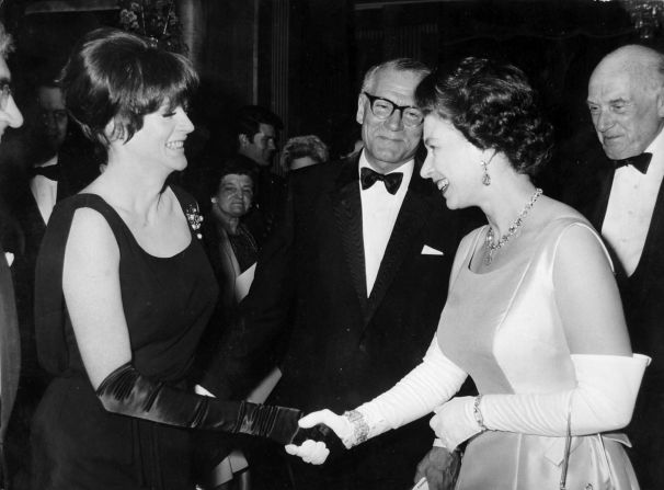 Smith shakes hands with Queen Elizabeth II at a premiere of "Othello" in London in 1966.