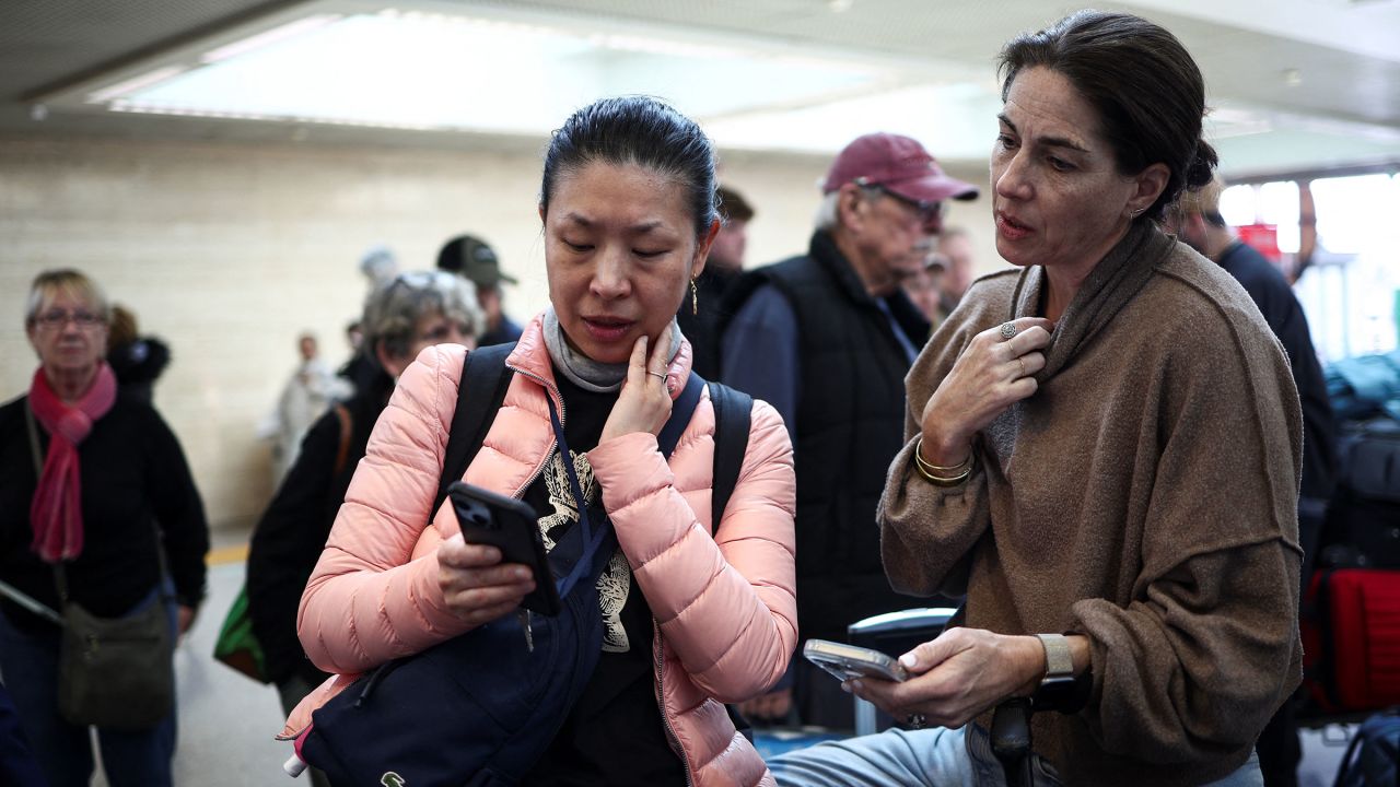 Carol Ye from Canada checks her phone as she waits to fly to Toronto via Heathrow International Airport, after a fire at an electrical substation wiped out the power at Heathrow International Airport,  at Fiumicino Airport near Rome, Italy, March 21, 2025. REUTERS/Guglielmo Mangiapane