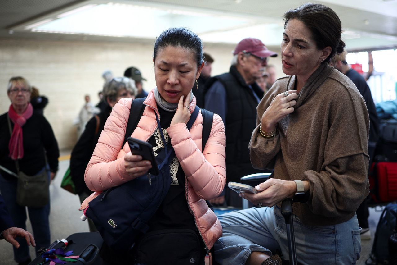 Carol Ye checks her phone as she waits to fly to Toronto via Heathrow, at Fiumicino Airport near Rome.
