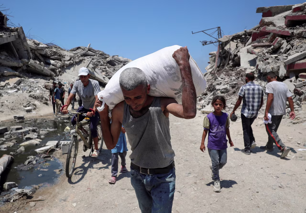 A Palestinian carries a bag with aid supplies that entered Gaza through Israel, in Beit Lahia in the northern Gaza Strip on July 27.