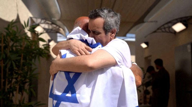 Omri Miran embraces his father Dani in Re'im, Israel, after his release from captivity on Monday.