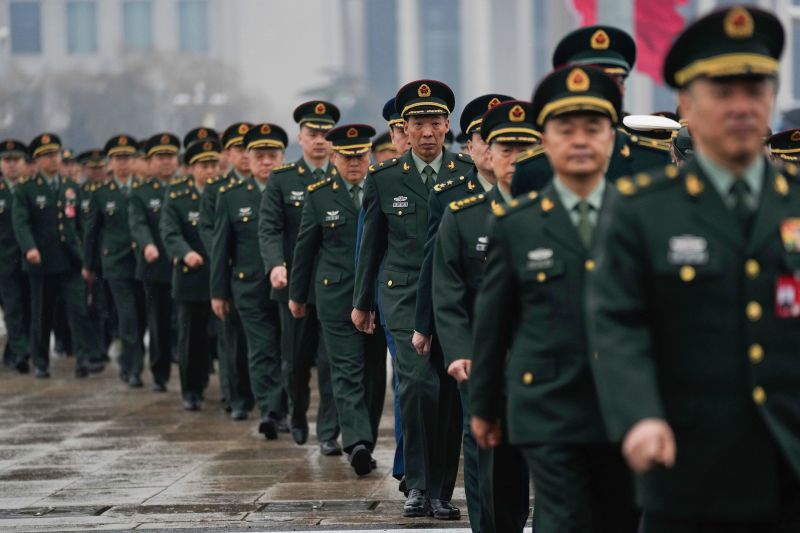 Delegates arrive at Beijing's Great Hall of the People on March 5 to attend the opening session of the National People's Congress annual meeting.