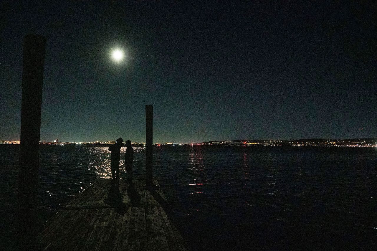 A helicopter uses its searchlight as it flies above the Potomac River during search operations.