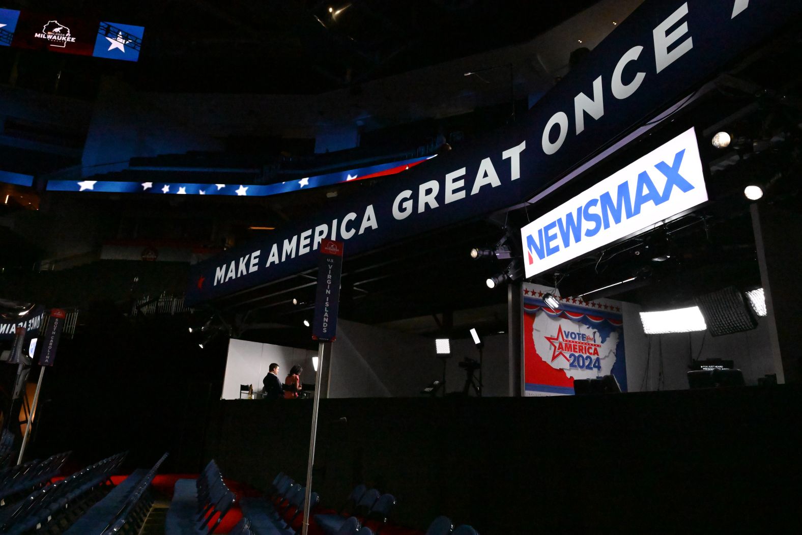 Television reporters work at the convention site on Sunday.