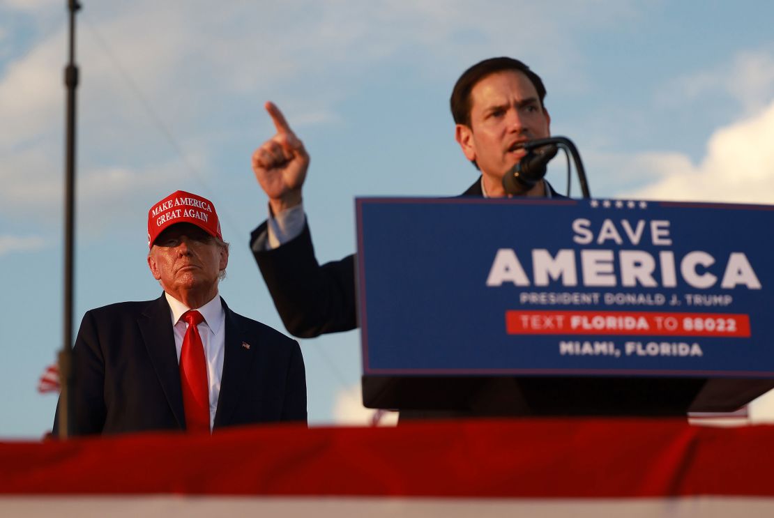 Former President Donald Trump listens as Sen. Marco Rubio speaks during a rally at the Miami-Dade County Fair and Exposition on November 6, 2022 in Miami, Florida.