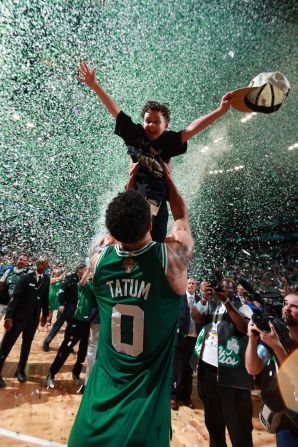 Boston Celtics star Jayson Tatum lifts his son, Deuce, after the <a href=