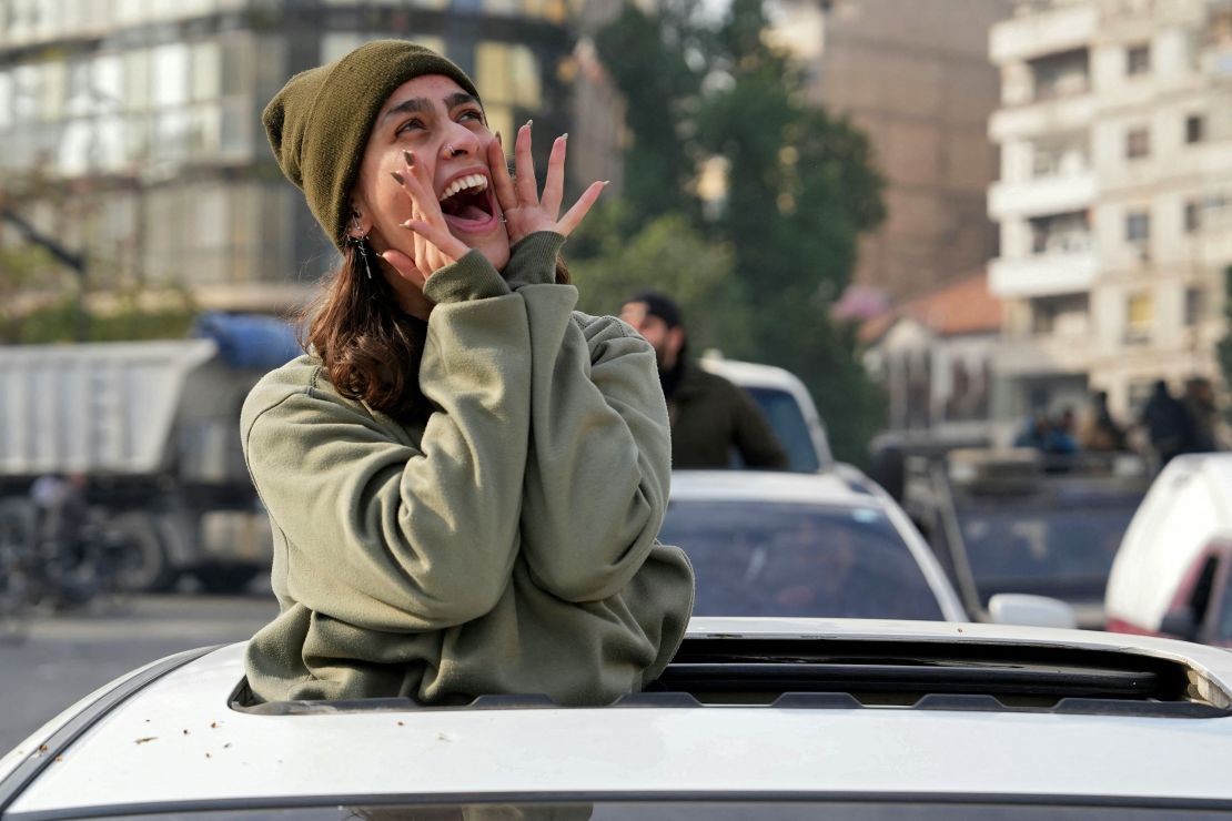 A woman cries out from a car in Homs, in western Syria, on Sunday, after residents across the country celebrated the fall of the Assad regime to rebel forces.