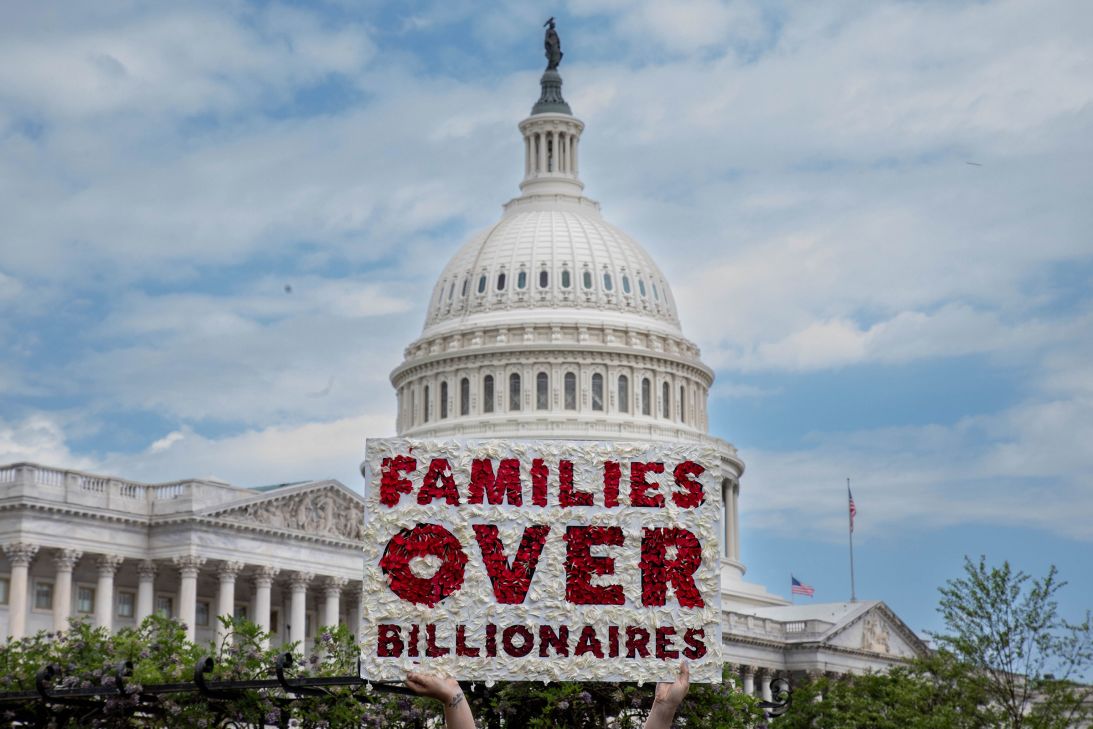 A member of MomsRising holds a sign during a rally opposing Medicaid cuts and tax cuts for the wealthy, near the US Capitol on May 8.