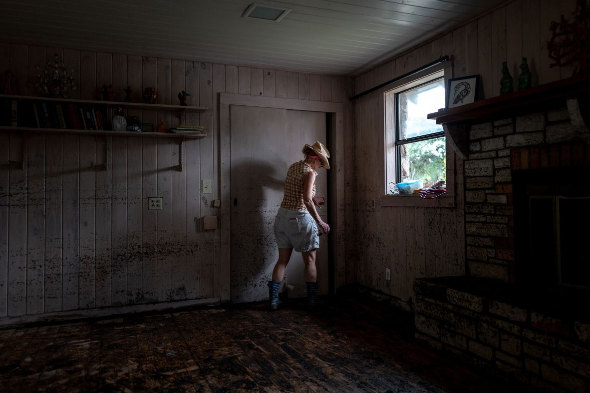 Nancy Callery works to salvage belongings from her childhood home in Hunt, Texas, on Wednesday, July 9. "This is completely devastating for my whole family to the point that we haven't even told my mom because we don't want to worry her," said Callery. "This was our little bit of paradise."