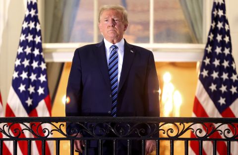 President Donald Trump stands on the Truman Balcony after returning to the White House from Walter Reed National Military Medical Center on October 5 in Washington, DC. 