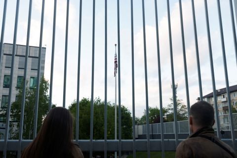 People watch as the American flag is raised at the US embassy in Kyiv on Wednesday. 