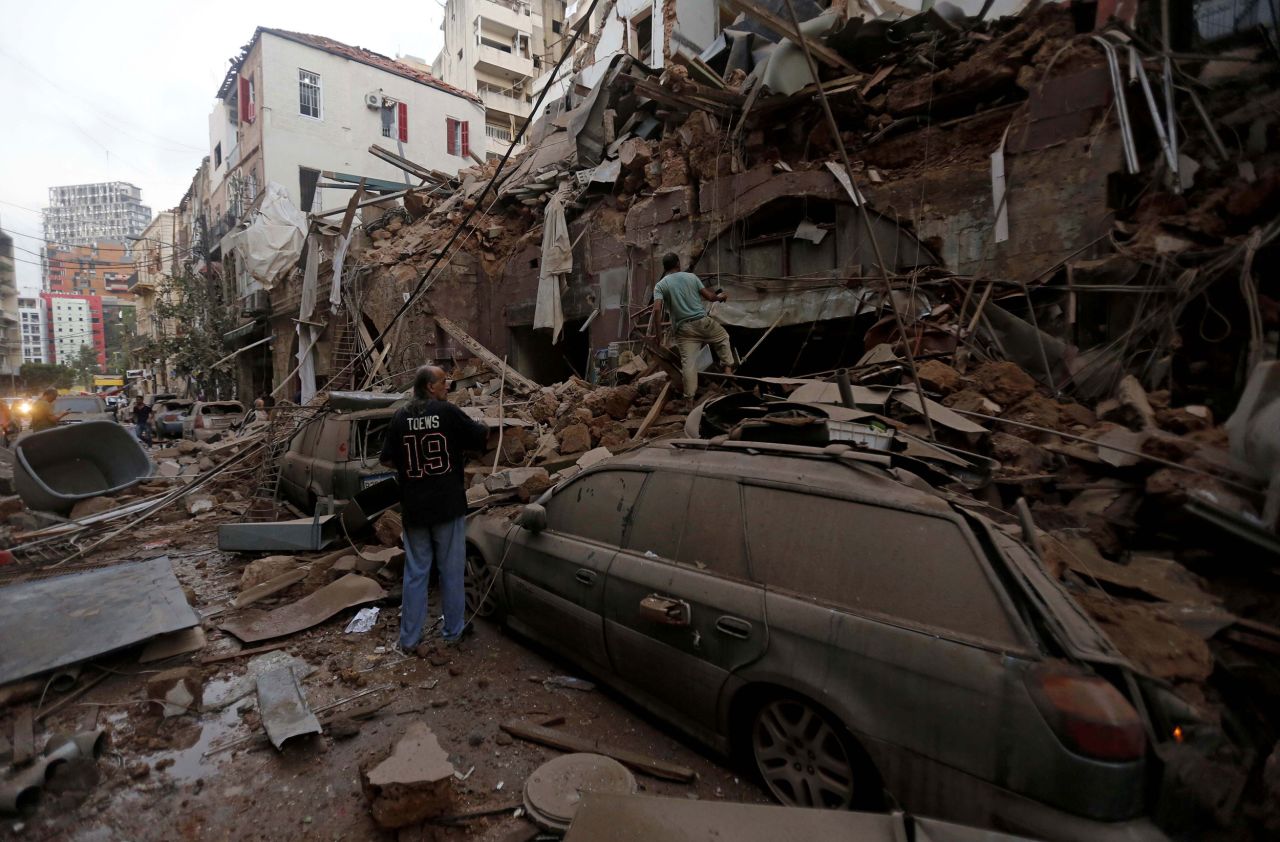 People stand on a pile of rubble in Beirut on August 4.