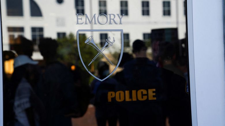 Campus police officer and demonstrators stand inside of an admissions building after students staged a walk out in support of Palestinians at Emory University in Atlanta on Wednesday, May 1.