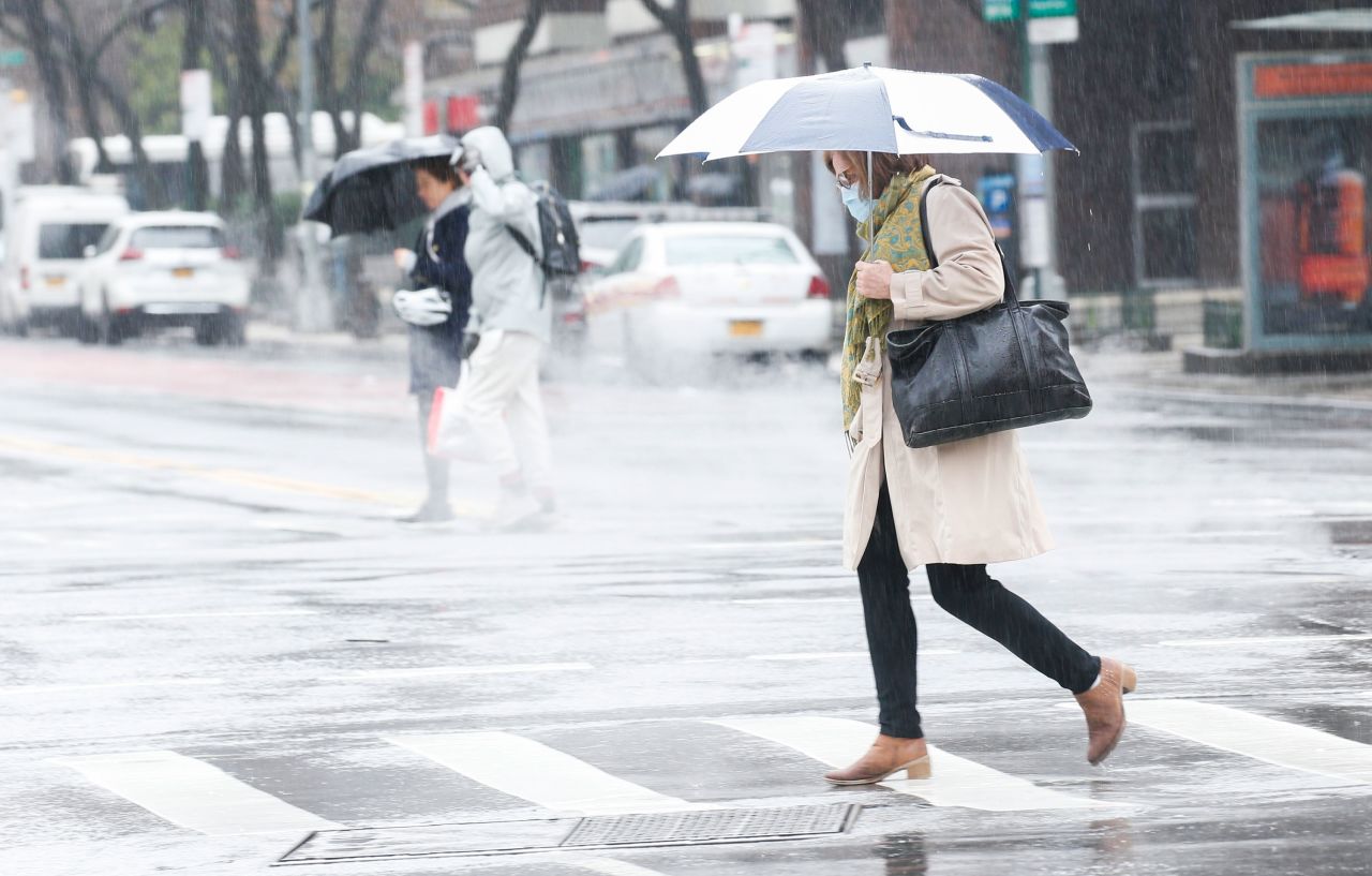 A woman wearing a facemask crosses the street on March 28 in New York City.
