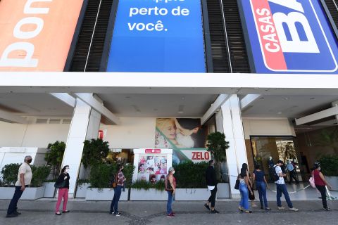 People wait in line to have their body temperature checked before entering a shopping mall in Brasilia, Brazil, on May 27.