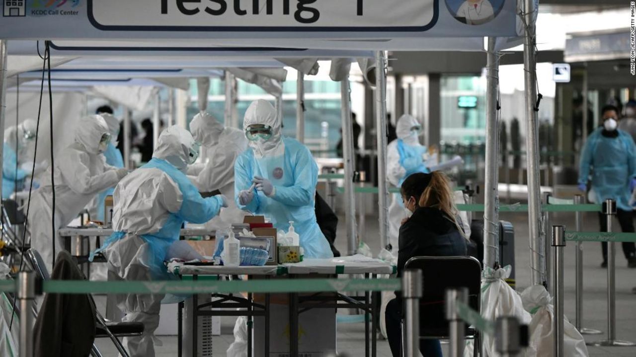 Medical staff wearing protective clothing take test samples for the coronavirus from a passenger at a virus testing booth outside Incheon International Airport, west of Seoul, on April 1. 