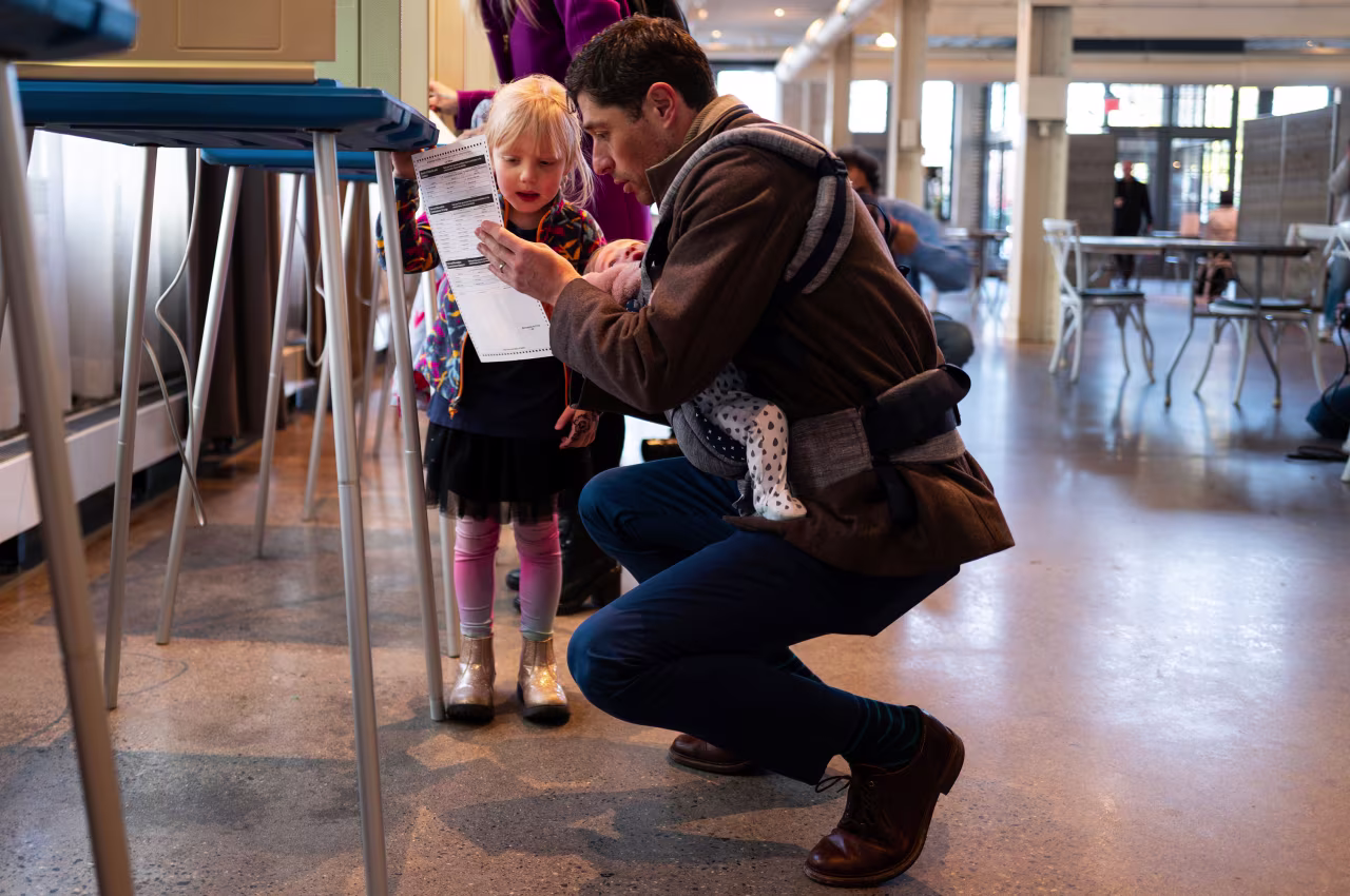 Minneapolis Mayor Jacob Frey fills out his ballot with his daughters Freida and Estelle in Minneapolis.