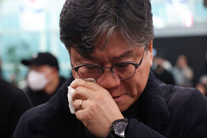 A relative of one of the aircraft's passengers wipes his face at Muan International Airport, as people waited for news of their loved ones.