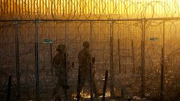 Members of the Texas National Guard stand guard near a razor wire fence to inhibit the crossing of migrants into the United States, seen from Ciudad Juarez, Mexico, June 4, 2024. REUTERS/Jose Luis Gonzalez