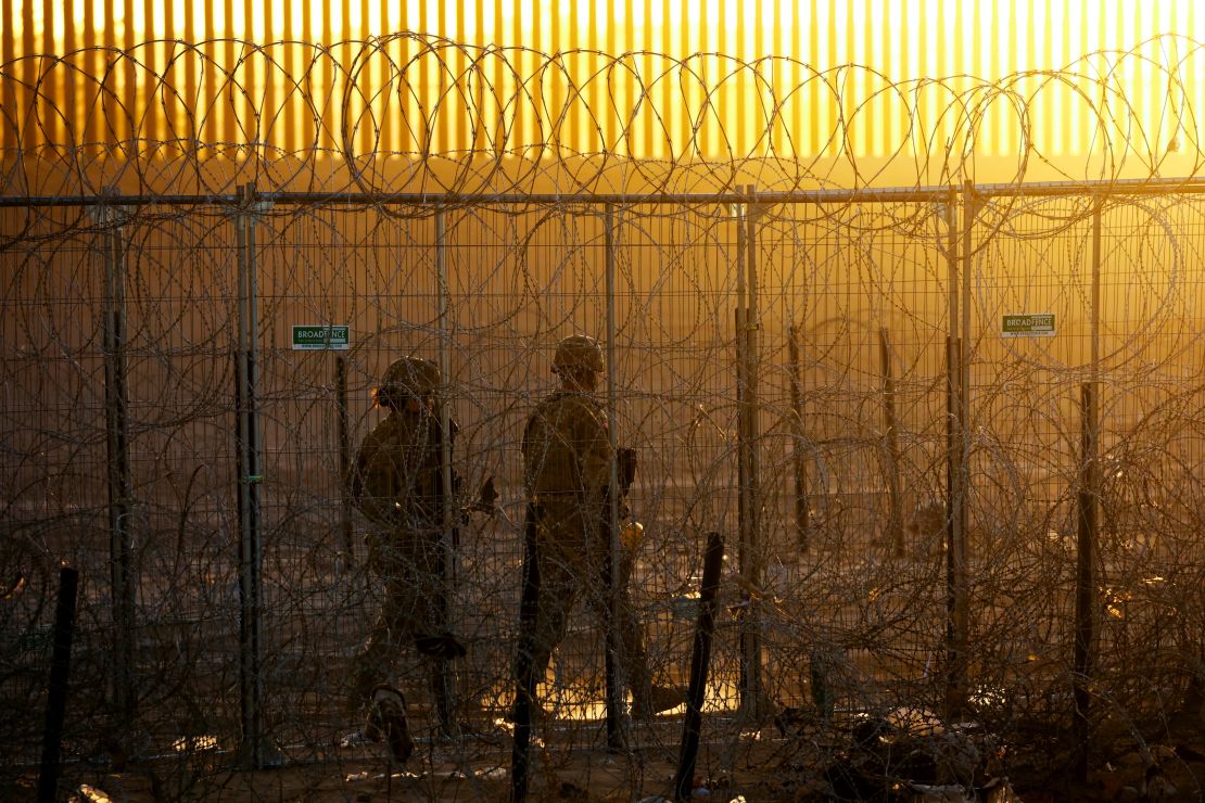 Members of the Texas National Guard stand guard near a razor wire fence to inhibit the crossing of migrants into the United States, seen from Ciudad Juarez, Mexico, June 4, 2024. REUTERS/Jose Luis Gonzalez