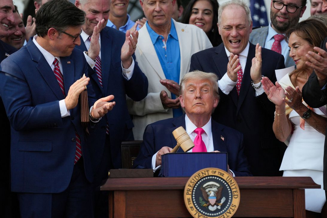 House of Representatives Speaker Mike Johnson and House Majority Leader Steve Scalise applaud as President Donald Trump holds a gavel after signing the 