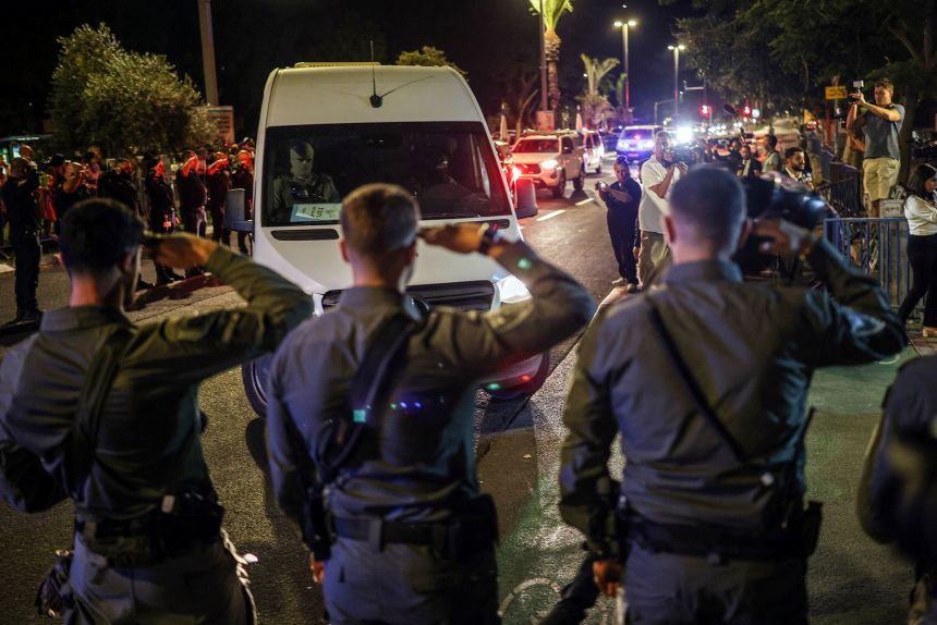 Israeli policemen salute as vehicles carrying bodies of four deceased hostages, who had been held in Gaza since the deadly October 7, 2023 attack, arrive at forensic institute in Tel Aviv, Israel, on October 13, 2025.