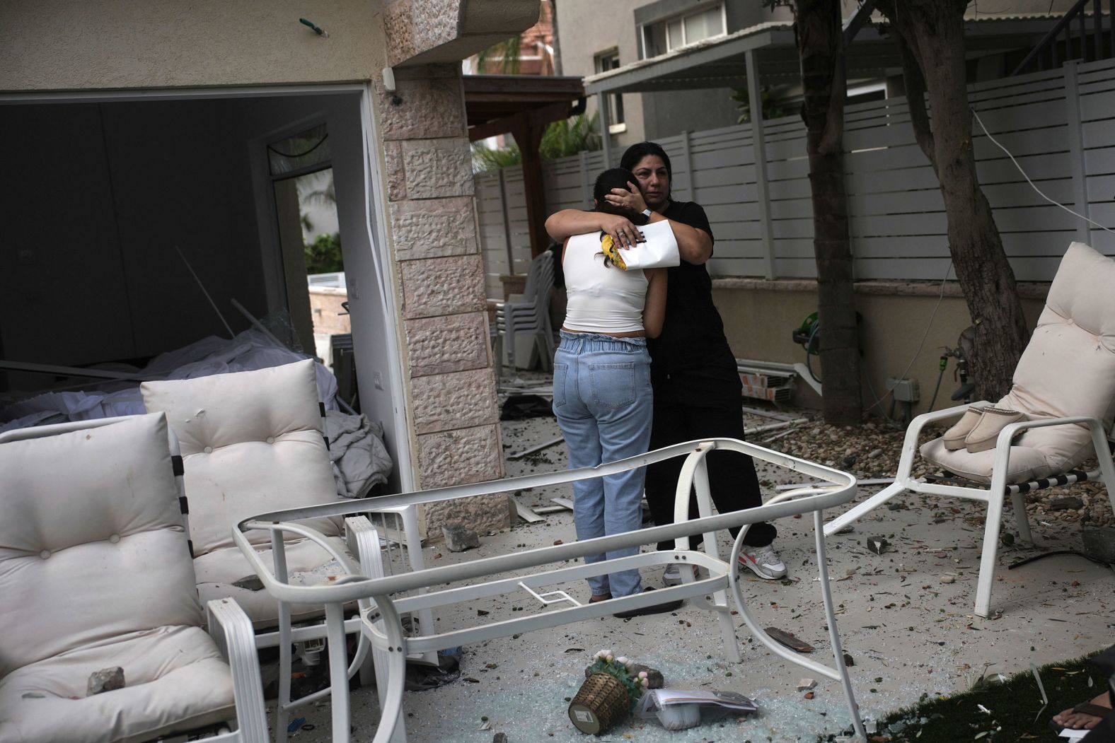 People embrace outside their damaged home in Rishon Lezion on Saturday.