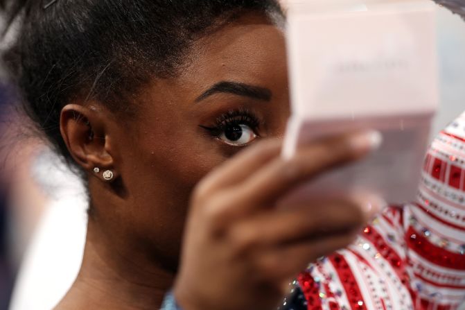 Biles checks herself in a mirror during the competition.