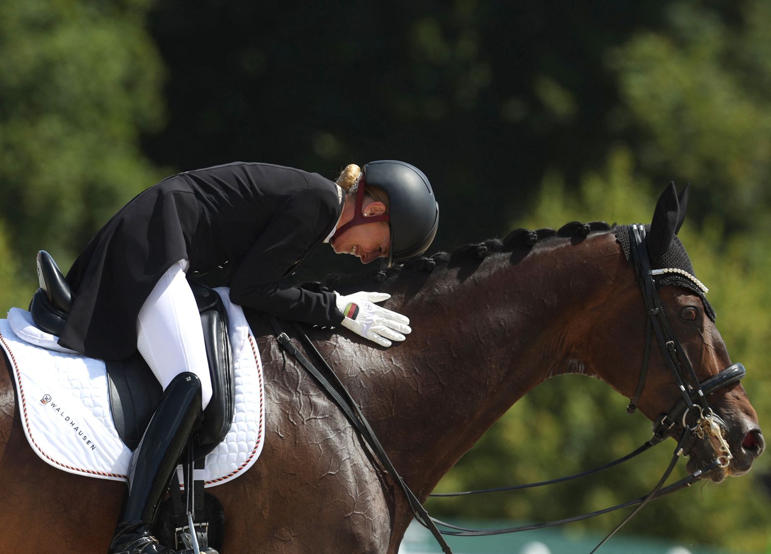 Germany's Jessica von Bredow-Werndl pets her horse TSF Dalera BB after <a >winning the individual dressage title</a> on August 4.