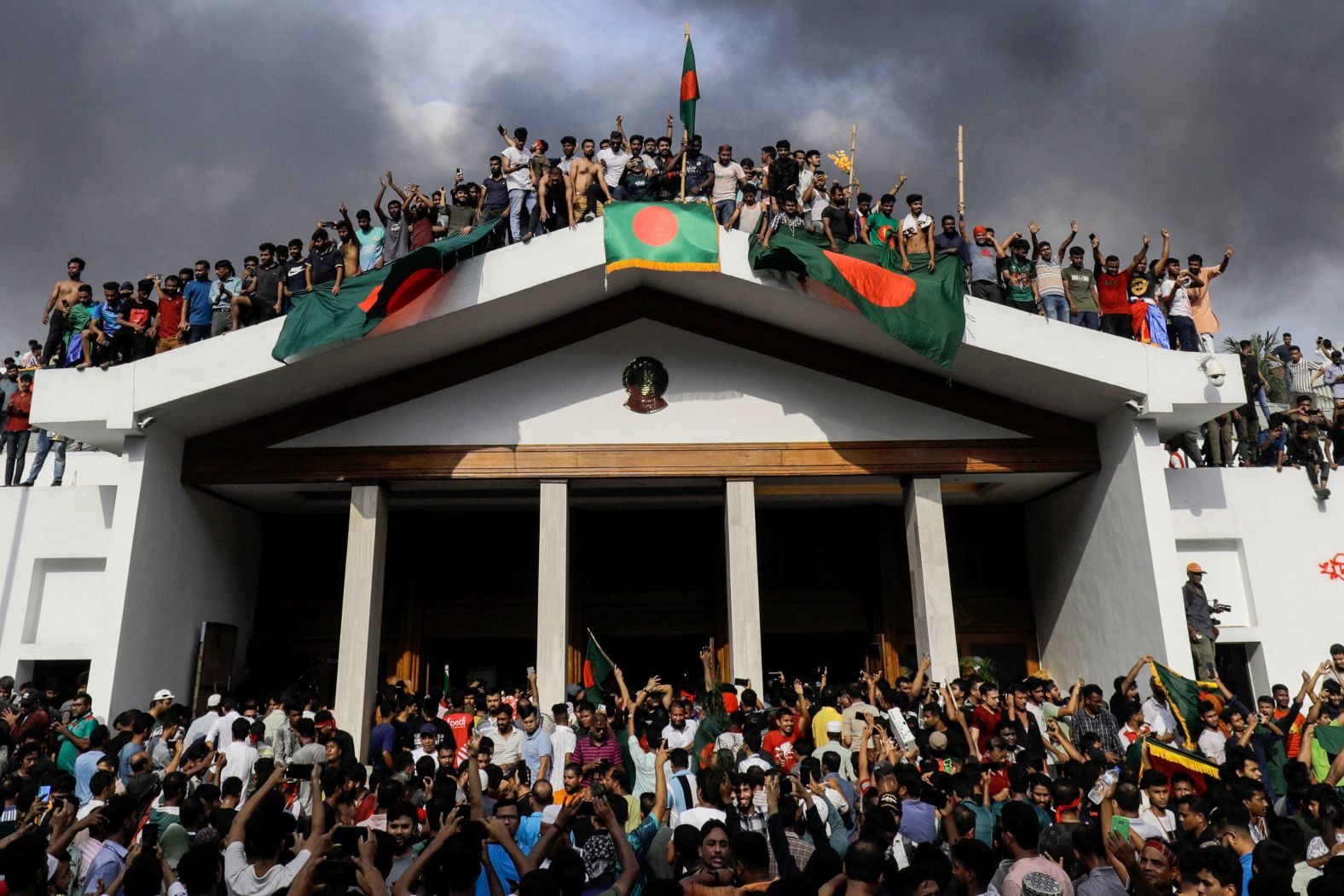 Anti-government protesters display Bangladesh's national flag as they <a href="index.php?page=&url=https%3A%2F%2Fwww.cnn.com%2F2024%2F08%2F05%2Fasia%2Fbangladesh-prime-minister-residence-stormed-intl%2Findex.html">storm the palace of Prime Minister Sheikh Hasina</a> in Dhaka on Monday, August 5. Hasina resigned and fled to neighboring India.