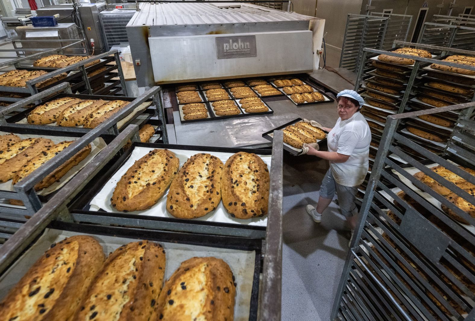 Antje Schmiedel-Viertel takes trays of stollen out of the oven at the Annaberger Backwaren bakery in Annaberg-Buchholz, Germany, on Wednesday, August 15. Stollen is a traditional fruit bread enjoyed across Germany during the Christmas season.