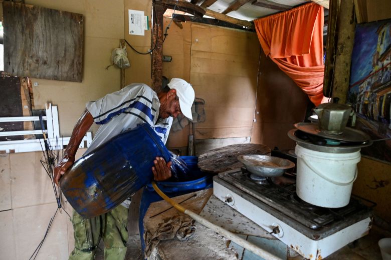 A man pours water into a plastic drum for use at home in Havana in September 2024.
