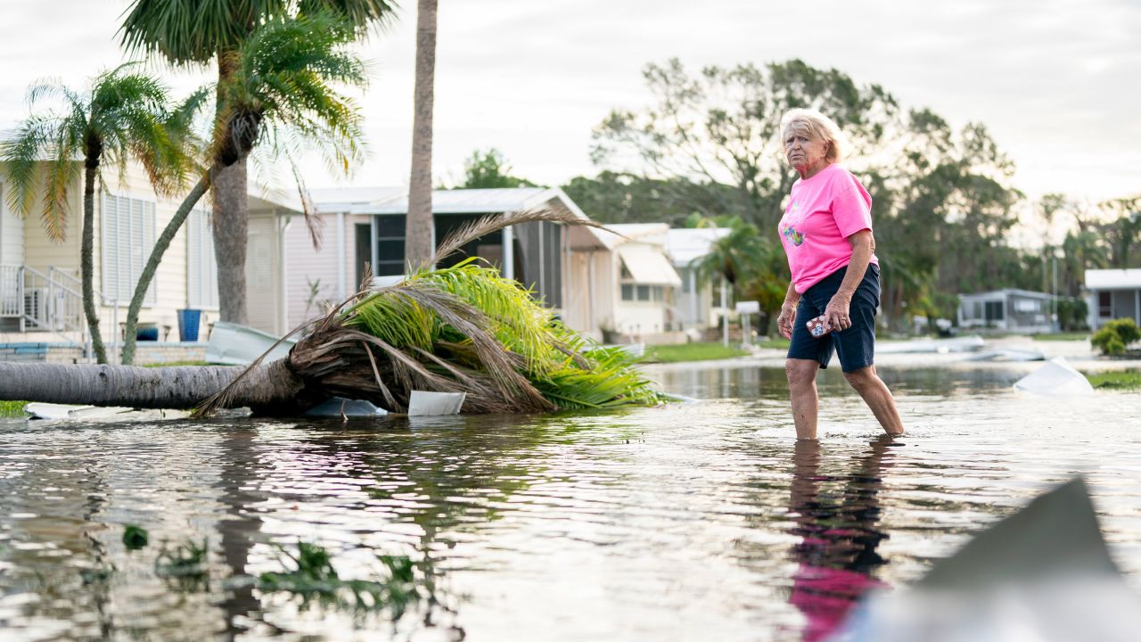 OSPREY, FLORIDA - OCTOBER 10: A woman walks along a flooded street in the aftermath of Hurricane Milton on October 10, 2024 in Osprey, Florida. The hurricane made landfall as a Category 3 hurricane in the Siesta Key area. (Photo by Sean Rayford/Getty Images)