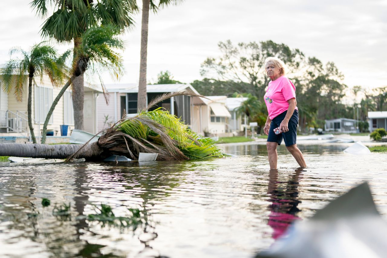 A woman walks along a flooded street in the aftermath of Hurricane Milton on Thursday, October 10, in Osprey, Florida.