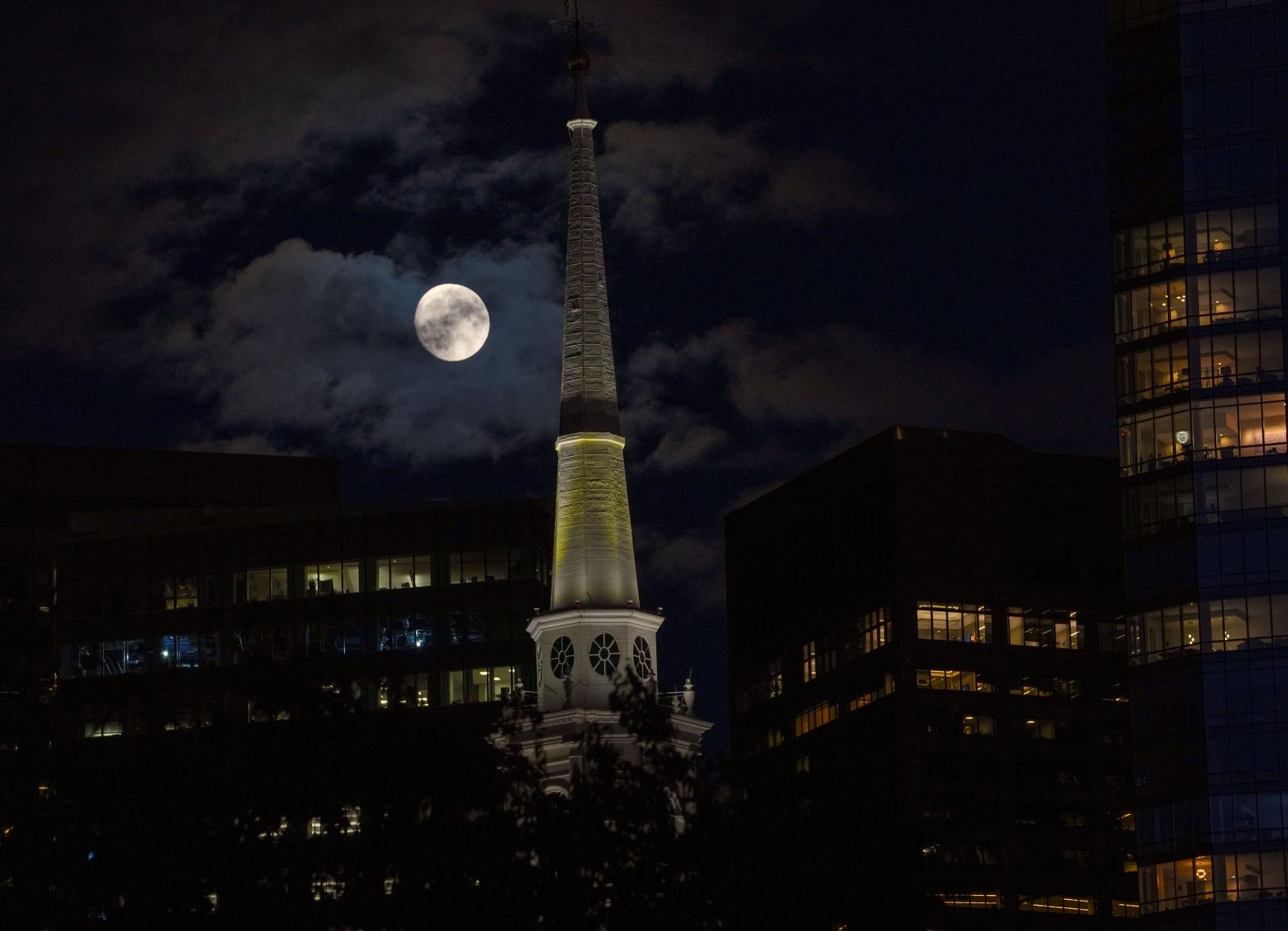 The moon rises in the sky over Boston on Tuesday.